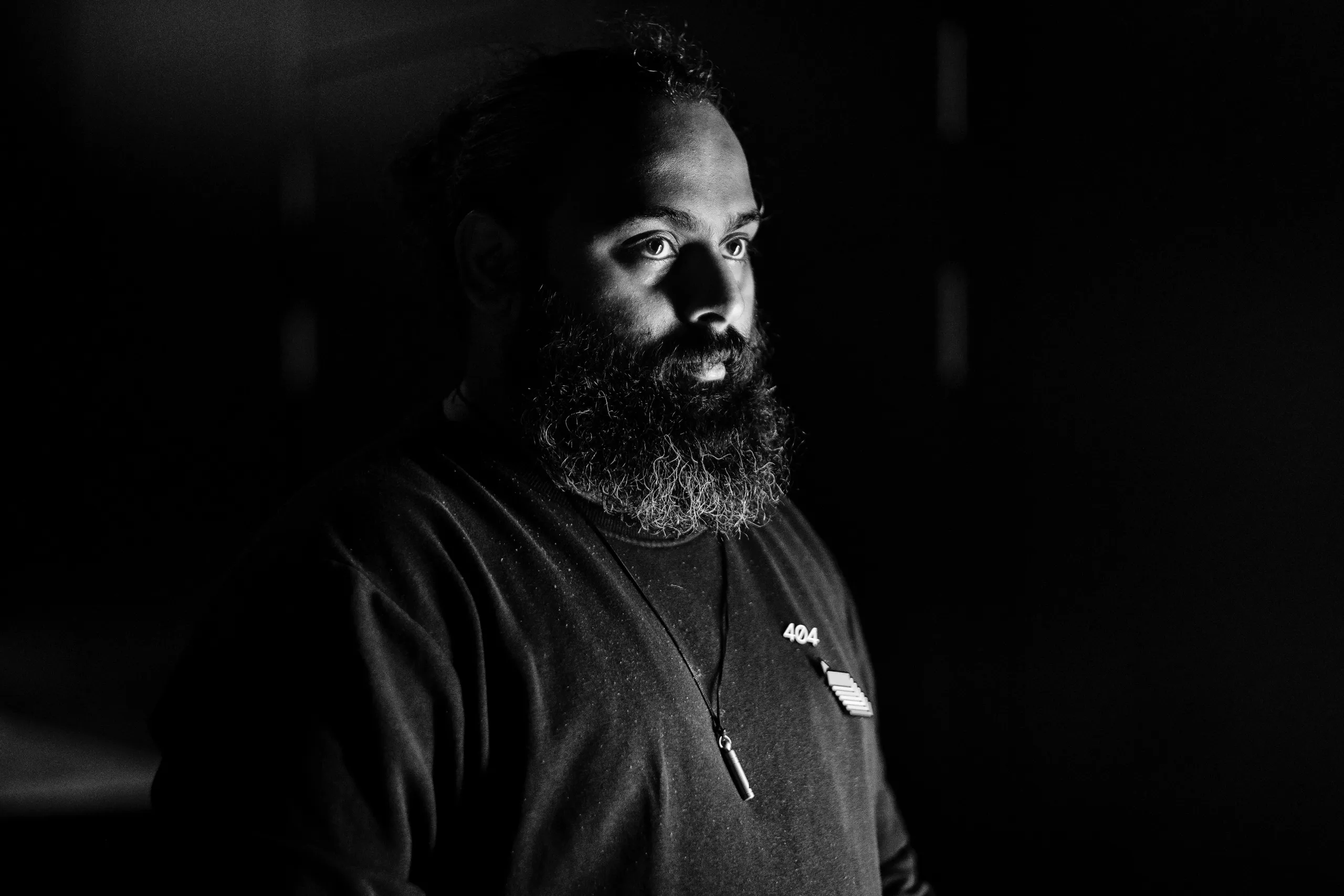 Portrait of Bobby Kariyatty, lit from one side against a dark background.